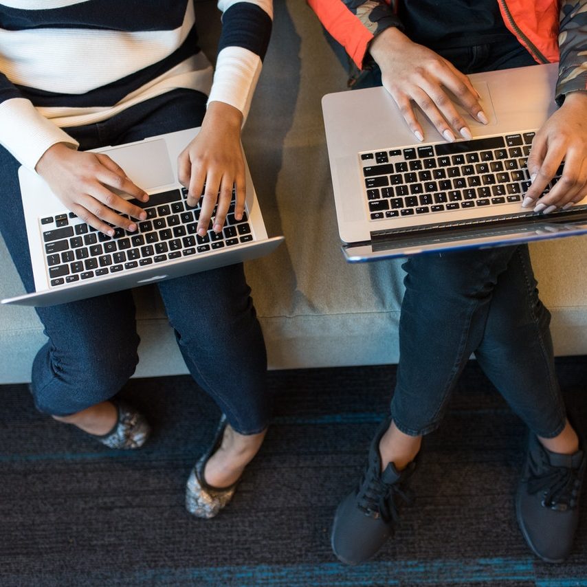 women typing on their laptops